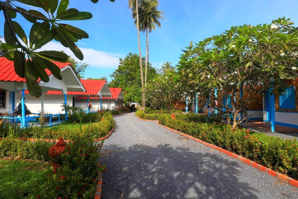 Colourful deluxe bungalows along a tropical garden path at Isara Lanta resort